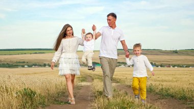 Genç çift, çocuklarla el ele yürür.