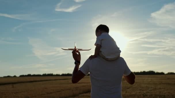 Mann trägt Kleinkind-Sohn auf Schultern und Spielzeugflugzeug in der Hand — Stockvideo