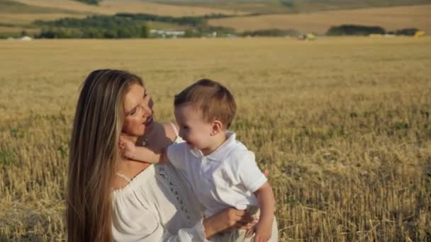 Młoda matka trzyma małego synka w ramionach i przytula się — Wideo stockowe