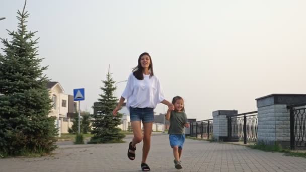 Koreanisches Mädchen läuft mit Mutter Hand in Hand Böschung entlang — Stockvideo