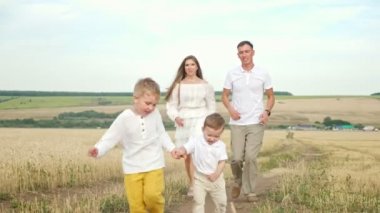 Ebeveynler ve oğulları yazın buğday tarlasında çiftler halinde koşar.
