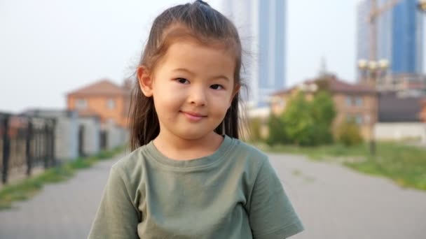 Μικρό κορίτσι από την Ασία ποζάρει για την κάμερα στην προκυμαία το καλοκαίρι — Αρχείο Βίντεο