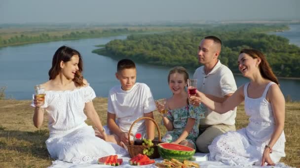 Föräldrar med barn klinkar glas läsk på picknick — Stockvideo