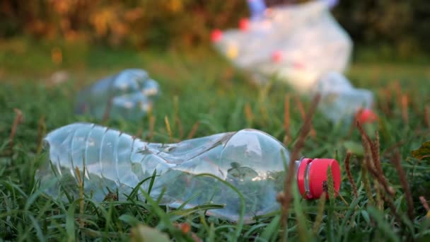 Unrecognizable person collects trash in gloves, blurred background, close-up of a plastic bottle — Stock Video