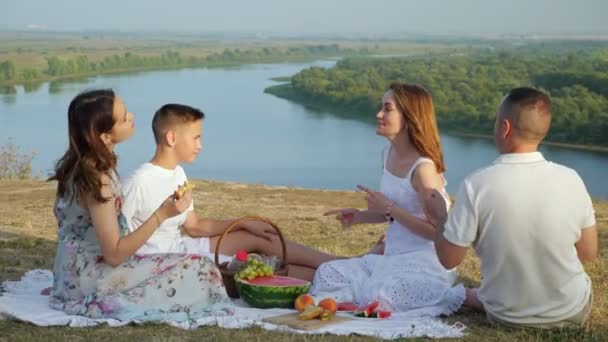 Positiva barn och föräldrar dansar på picknick nära floden — Stockvideo