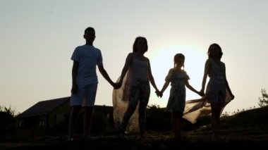 Çocukların el kaldırdığı neşeli anne siluetleri.