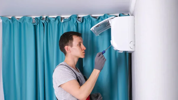 Zahuštěný pracovník odstraňuje šroub se šroubovákem na chladiči — Stock fotografie