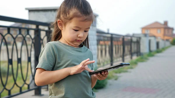 Annoyed aziatische meisje persen plakken toetsen op telefoon op de waterkant — Stockfoto