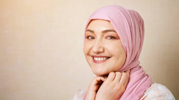 Musulmana mujer caucásica en rosa pañuelo de la cabeza sonrisas mirando a la cámara — Foto de Stock