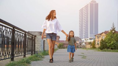 Annem küçük Koreli kızla setin yanında yürüyor.