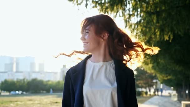 Šťastná žena třese dlouhými kudrnatými vlasy na moderní městské ulici — Stock video
