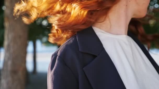 Femme en veste secoue les cheveux en cuivre debout sur la rue de la ville — Video