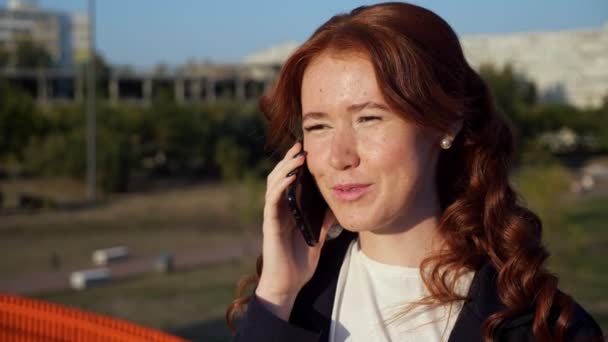 Jovem com manchas no rosto fala no telefone acima da rua — Vídeo de Stock