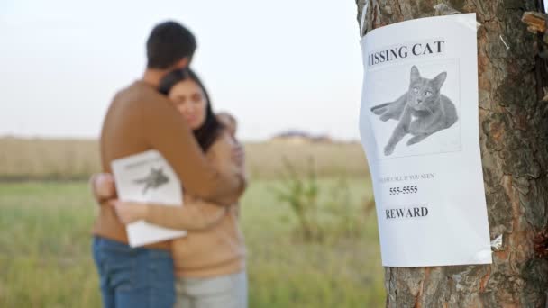 Abraços de casal perturbados no foco do parque no cartaz do gato desaparecido — Vídeo de Stock