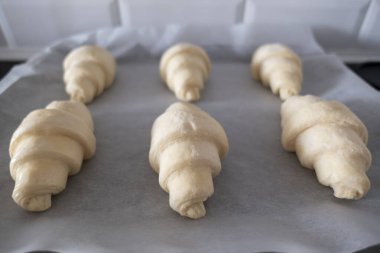 Kruvasan taze pişmemiş ve ev yapımı kahvaltı için kağıt hazırlıyor.
