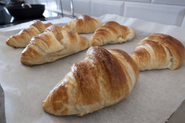 Kruvasan taze pişmiş ve ev yapımı kahvaltı için kağıt hazırlıyor.