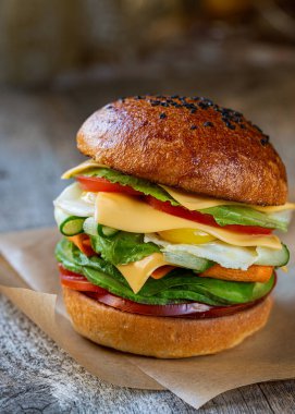 Sebzeli, peynirli ve bıldırcın yumurtalı vejetaryen burger. Mayasız tam tahıllı çörek. Bitki temelli diyet ve sağlıklı diyet kavramı.