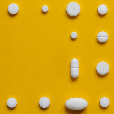 Sarı arka planda beyaz haplar. Eczacılık konsepti