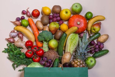 Market, arka planda farklı meyve ve sebzelerle dolu bir kese kağıdı. Market süpermarketi kavramı. Sağlıklı beslenme vegan. Düz ley