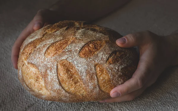 Homemade sourdough bread in men\'s hands.