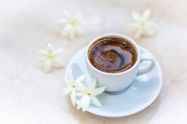 Geleneksel canlandırıcı Türk kahvesi. Beyaz bir fincan kahve çiçeklerle süslenir. Güzel besleme