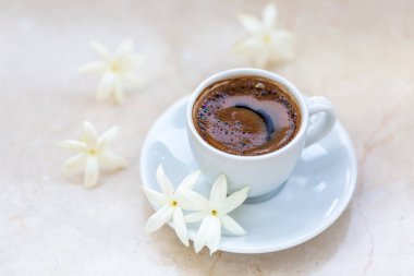 Geleneksel canlandırıcı Türk kahvesi. Beyaz bir fincan kahve çiçeklerle süslenir. Güzel besleme