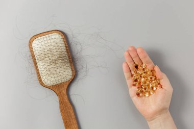 Tarak ve dökülmüş saçlar. Saç dökülmesi. Saç yenilenmesi için vitaminler