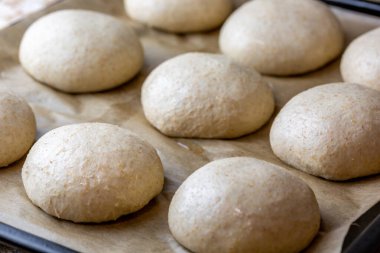 Tam tahıllı hamburger ekmeği. Pişirmeden önce hamuru düzeltiyorum. Hazırlık