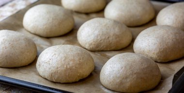 Tam tahıllı hamburger ekmeği. Pişirmeden önce hamuru düzeltiyorum. Hazırlık