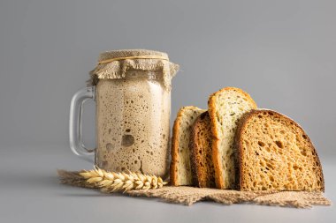 Active rye sourdough for bread and slices of natural whole grain bread clipart