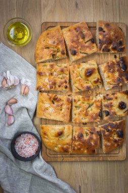 Geleneksel odak noktası, biberiye ve sarımsaklı doğal ekşi ekmek. Tahta arka planda tam tahıllı Focaccia. Zanaatkar 