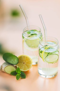 Sassi suyu. Limon, salatalık, zencefil ve nane ile detoks içeceği. Sağlıklı gıda konsepti. Cam pipetler