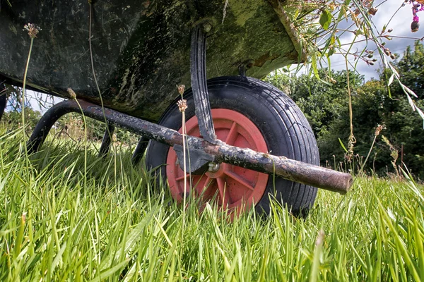 Carretilla de rueda de jardín en la hierba larga — Foto de Stock