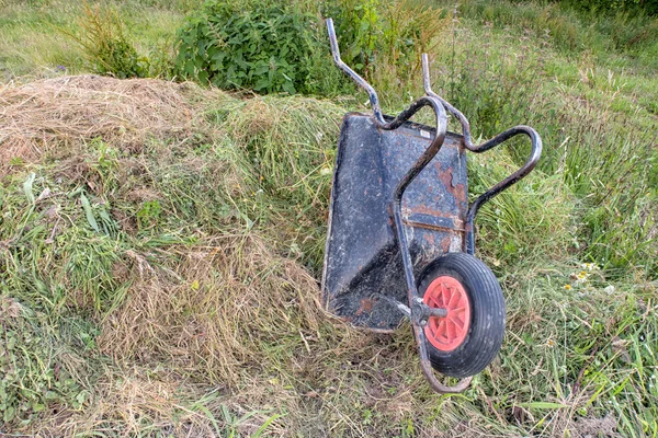 An upturned wheelbarrow on a compost heap — Stock Photo, Image