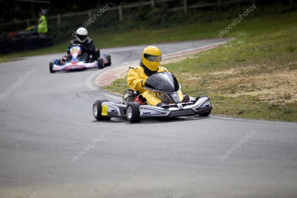 Two Racing Go Karts Zooming Along At Full Pace On The Race Circuit