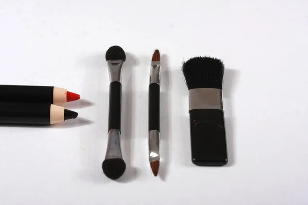 Makeup penslar och pennor på vit bakgrund — Stockfoto