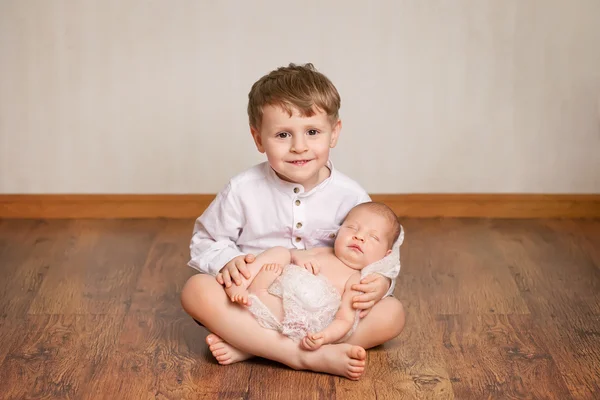Щасливий брат тримає свою новонароджену сестру — стокове фото