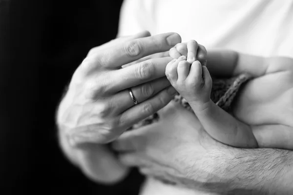 Новонароджена дитяча рука в руках батька. Чорно-біле фото . — стокове фото