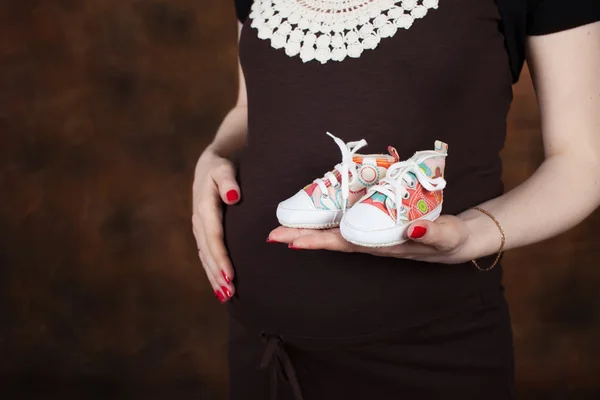 Nahaufnahme einer schwangeren Frau, die ihren Bauch mit den Händen berührt — Stockfoto