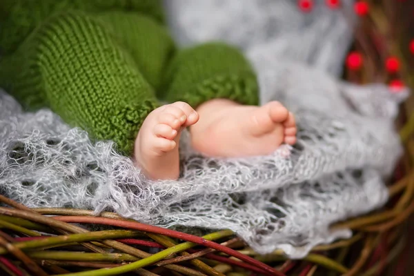 Крупный план новорожденных ног на вязаной клетке в ватт — стоковое фото