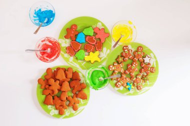 Tabaklarda zencefilli kurabiye ve beyaz masada zencefilli ekmek için çok renkli mastik. Noel pastası. Tatil, Noel, Yeni Yıl hazırlığı. 