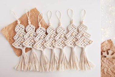 Noel makromu dekoru. Makrome tarzında bir Noel ağacı. Doğal malzemeler, pamuk ipliği, tahta boncuklar. Eko dekorasyonlar, süsler, el yapımı dekorasyon. Kış ve Yeni Yıl tatilleri