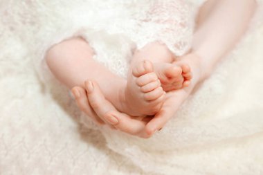 Bebek ayakları annenin ellerinde. Anne ve çocuğu. Mutlu aile kavramı. Anneliğin güzel kavramsal görüntüsü