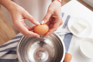 Yumurtaları kaseye kıran kadın. Yumurta kabuğuyla yumurta tutan eller