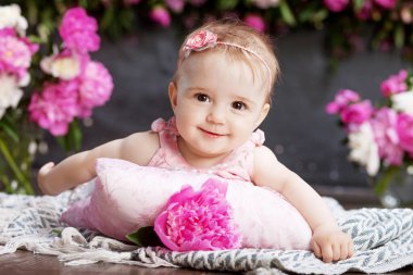 Pembe çiçekli güzel bir kızın portresi. Yüzükoyun uzanmış gülümseyen tatlı kız