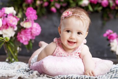 Pembe çiçekli güzel bir kızın portresi. Yüzükoyun uzanmış gülümseyen tatlı kız