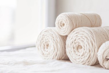 Beyaz arka planda el yapımı makrome örgü ve pamuk iplikleri. Makrome ve el sanatları afişleri ve reklamlar için hafif görüntü iyi. Boşluğu kopyala