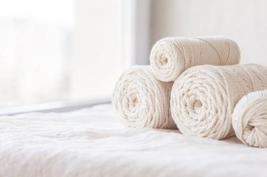 Beyaz arka planda el yapımı makrome örgü ve pamuk iplikleri. Makrome ve el sanatları afişleri ve reklamlar için hafif görüntü iyi. Boşluğu kopyala