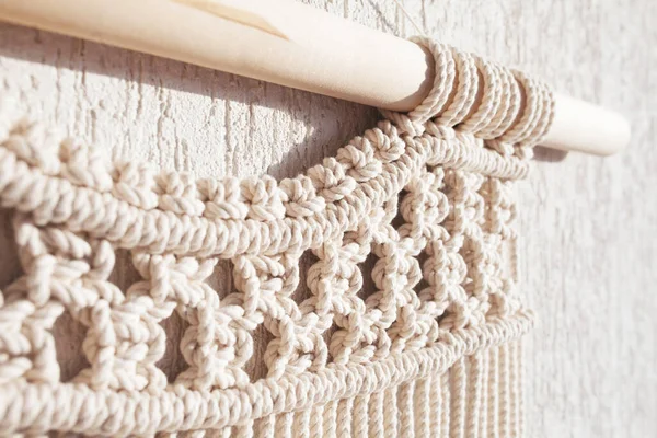 Close-up of hand made macrame texture pattern. ECO friendly modern knitting DIY natural decoration concept  in the interior.  Handmade macrame 100% cotton. Female hobby.