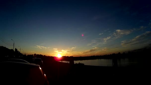 Bellissimo tramonto sulla costa vicino al fiume. Le nuvole attraversano il cielo. Le sagome delle persone possono essere viste sullo sfondo del sole. qualità hd, 1920x1080. lasso di tempo . — Video Stock